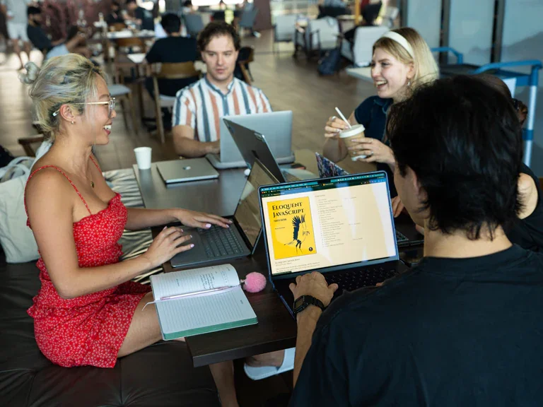 Network School members working together around a table